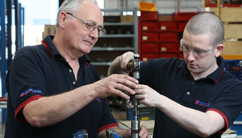 two fitters assemble a screw jack